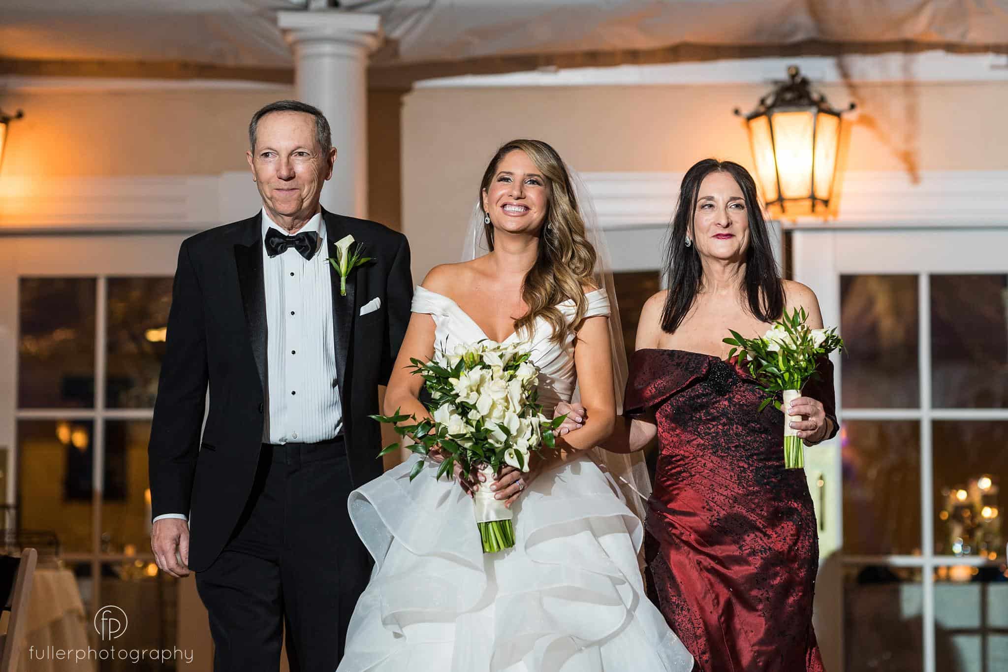 Bride and family walking down isle during indoor ceremony at Penn Oaks
