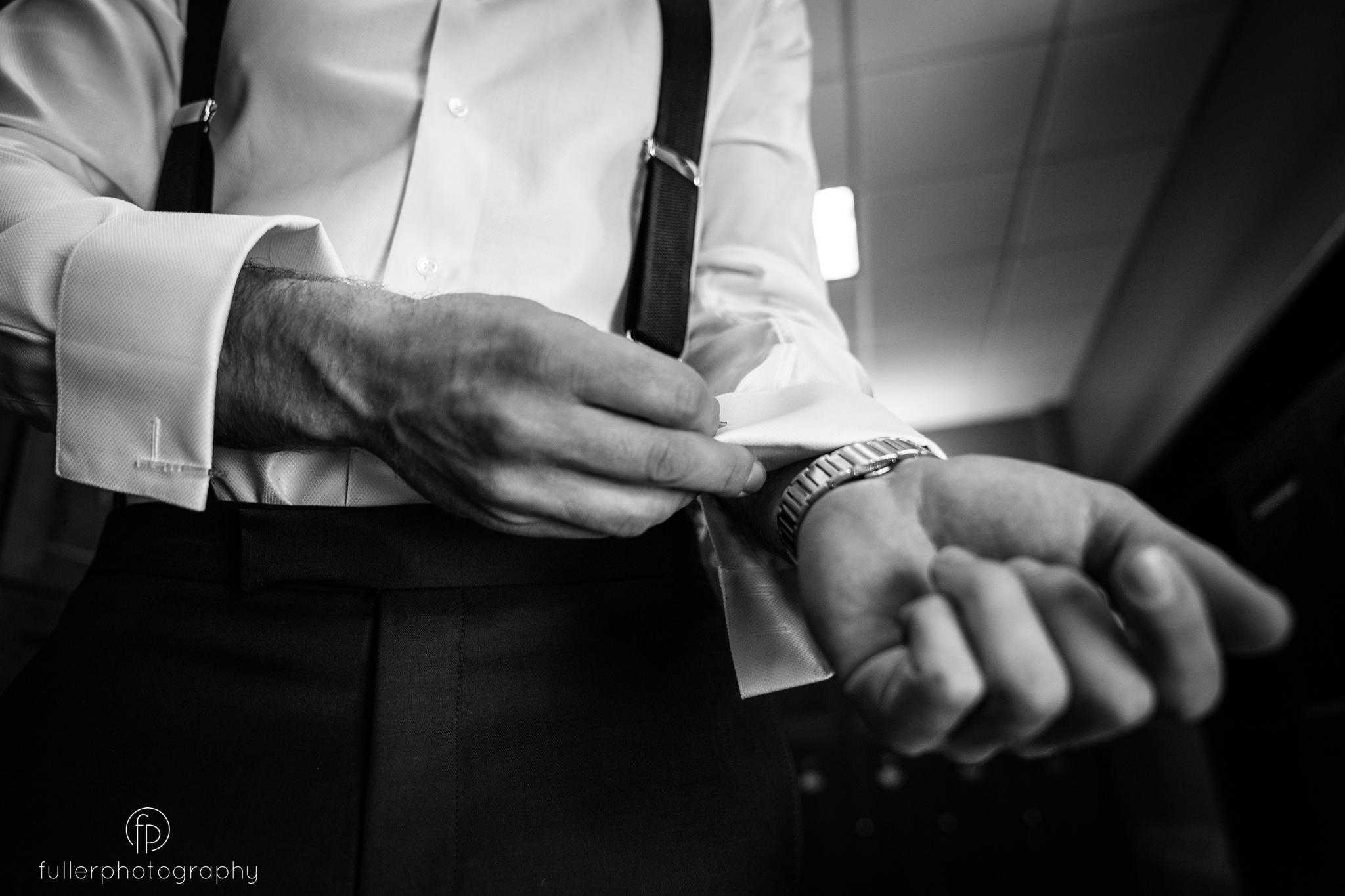 Groom buttoning his shirt