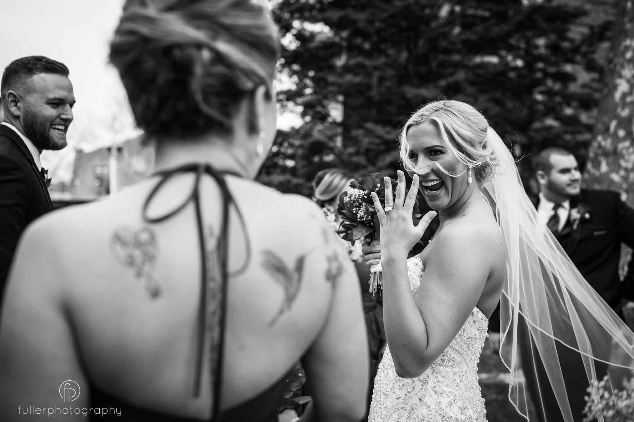The bride showing off her ring to her bridesmaid after getting married