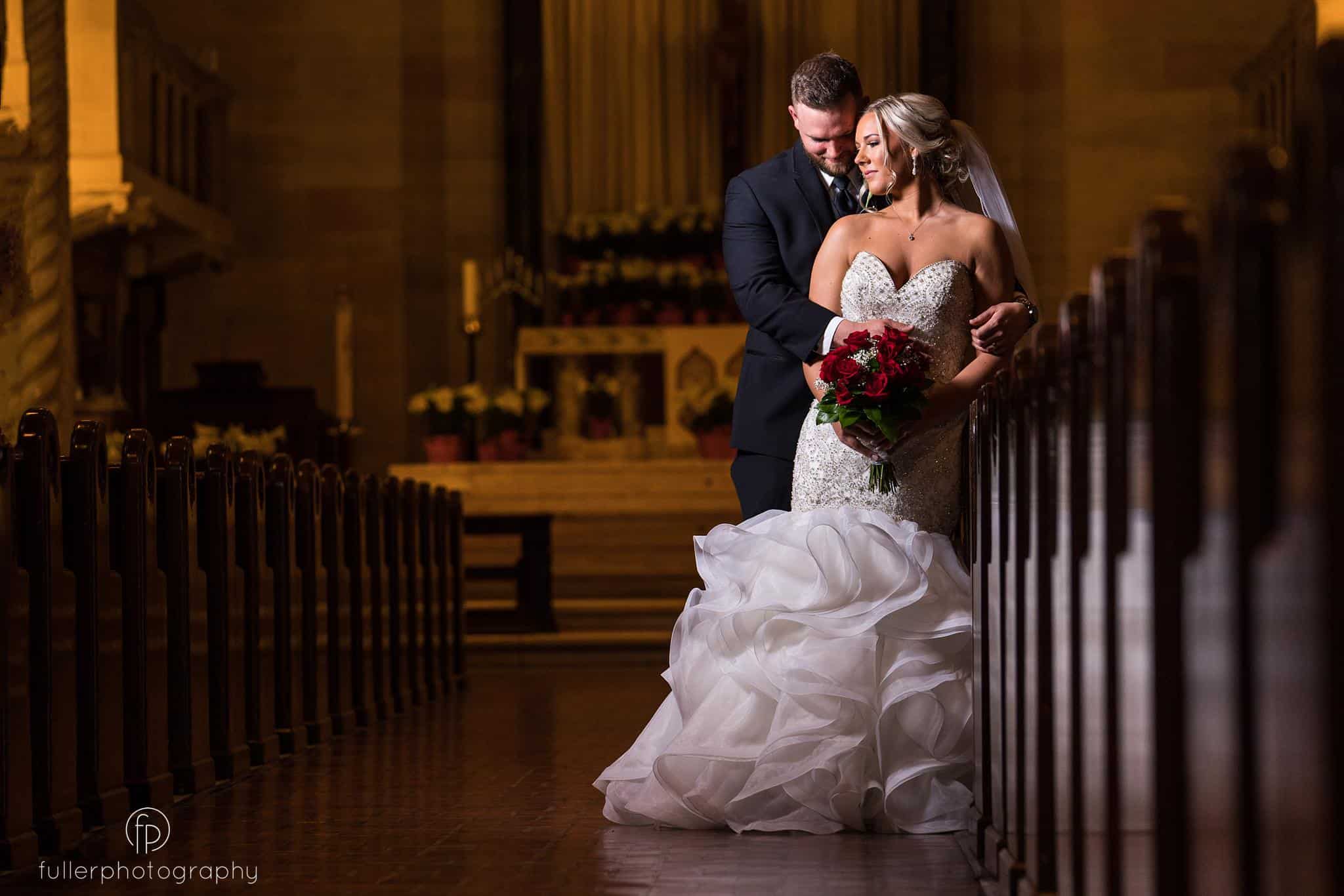 Groom hugging the bride during their wedding portraits inside of St Anthonys Church in Wilmington Delaware