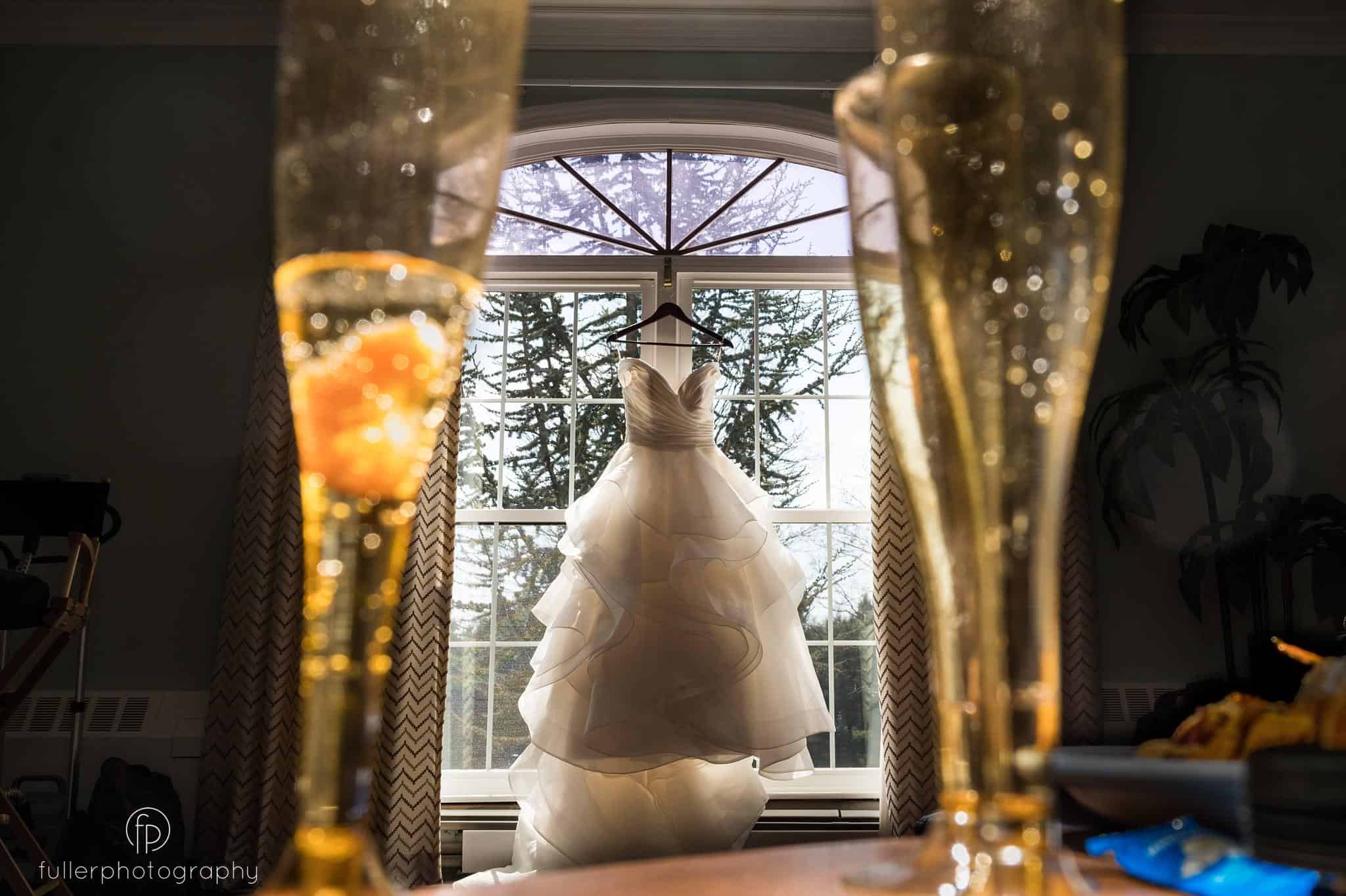 Wedding dress photo hanging in the Penn Oaks Bridal suite with champagne glasses