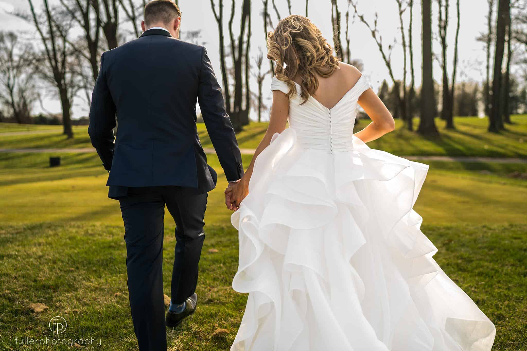 Bride and groom walking away on Penn Oaks Golf Course