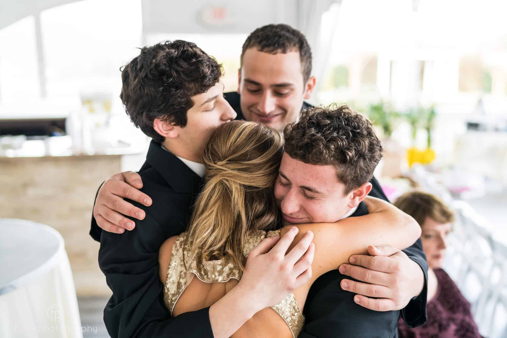 Maid of honor hugging her family before the wedding ceremony at penn oaks