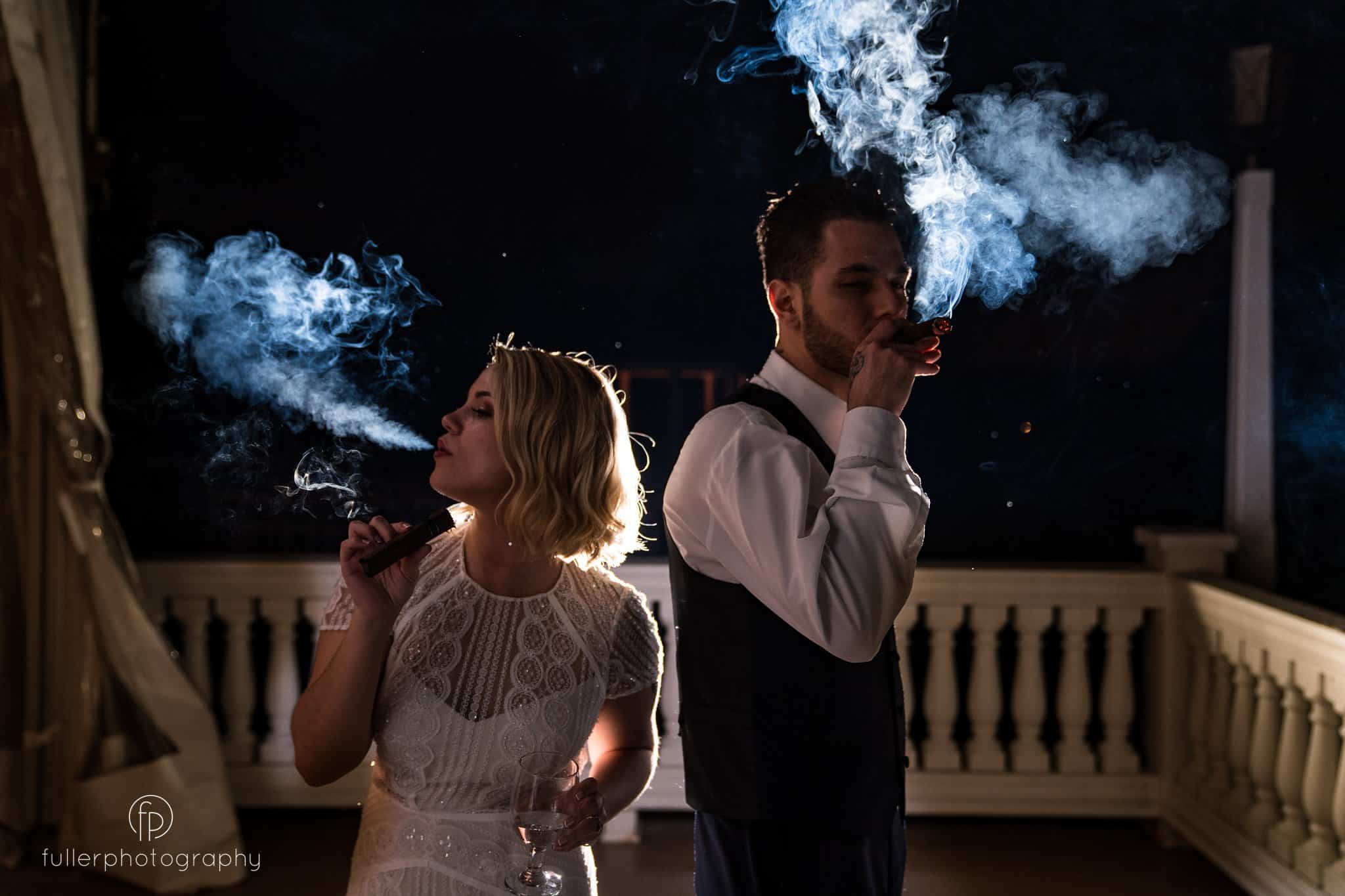bride and groom outside the Penn Oaks reception hall smoking cigars