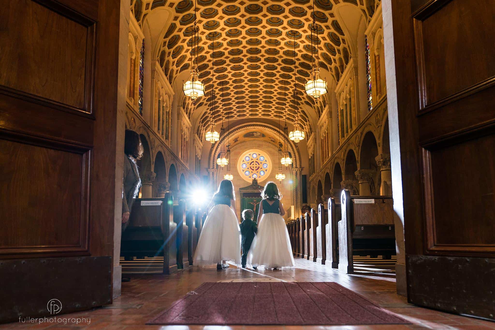 flower girls and ring bearer walking down the long aisle at St Anthonys