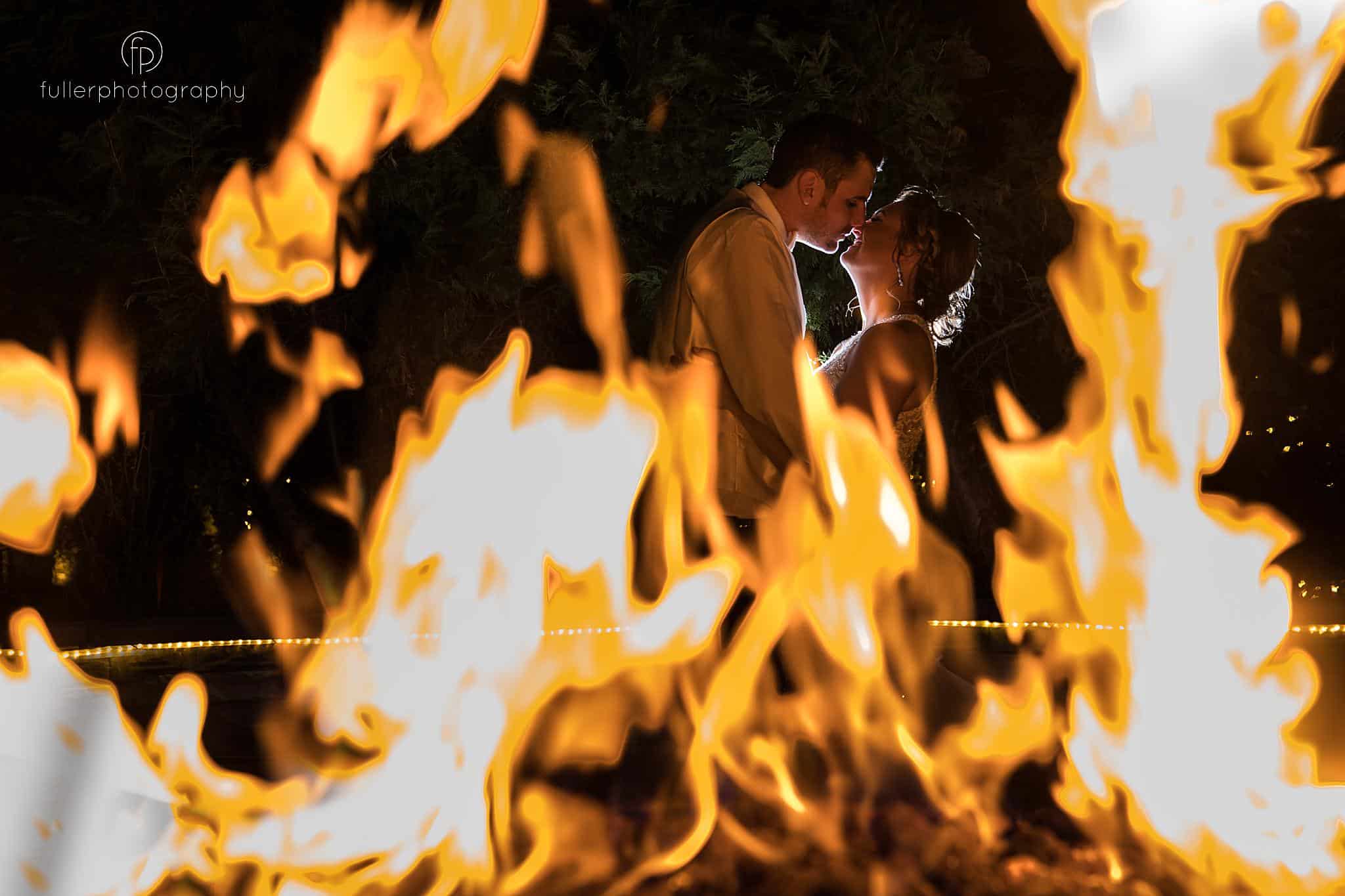Bride and Groom portrait looking through the fire at a Spring Lucien's Manor Wedding