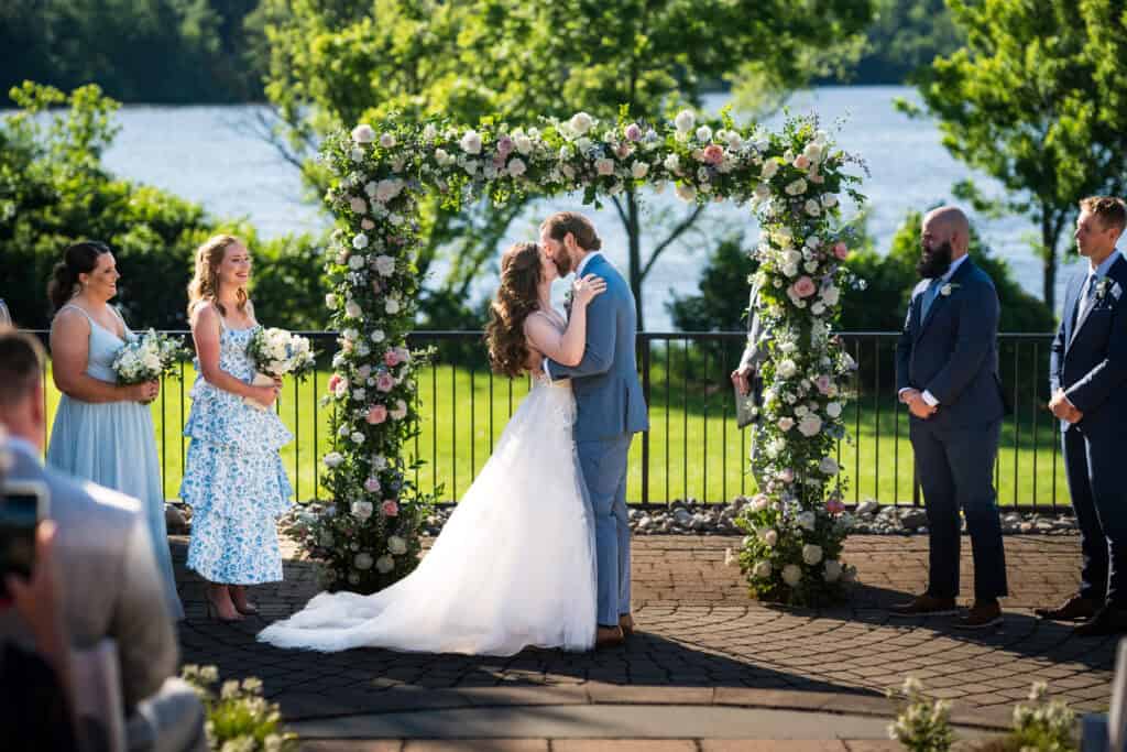 bride and groom first kiss during their outdoor ceremony at their Lake House Inn Wedding